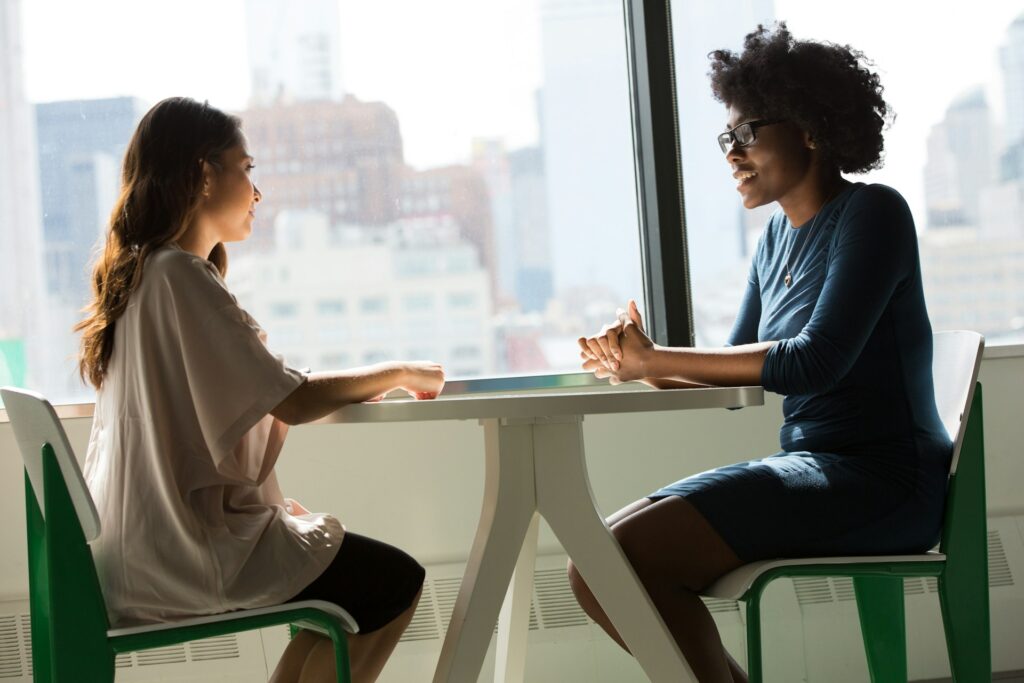 Gespräch zwischen zwei Frauen, die am Tisch sitzen